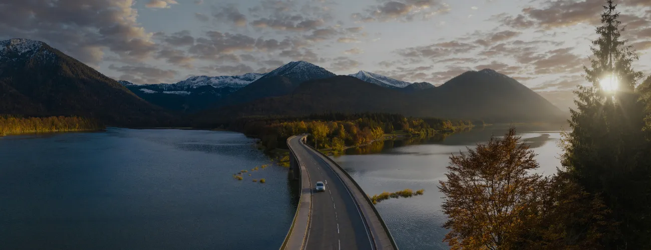 Car on a road with mountains in the background
